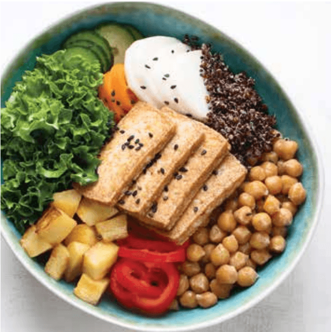 Colorful grain bowl with tofu, kale, quinoa, chickpeas, and vegetables